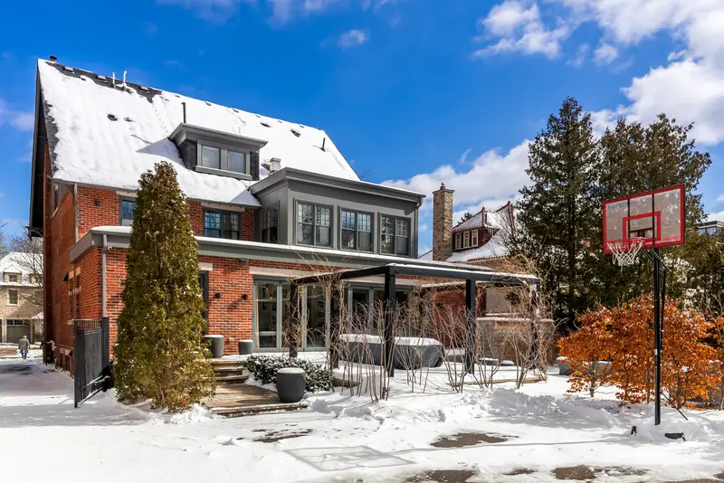 Rear of a brick home with pergola in winter