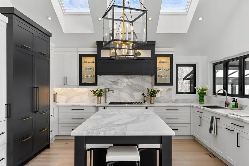 White kitchen with black island and skylights