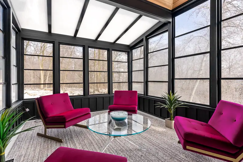 Black sunroom with magenta chairs