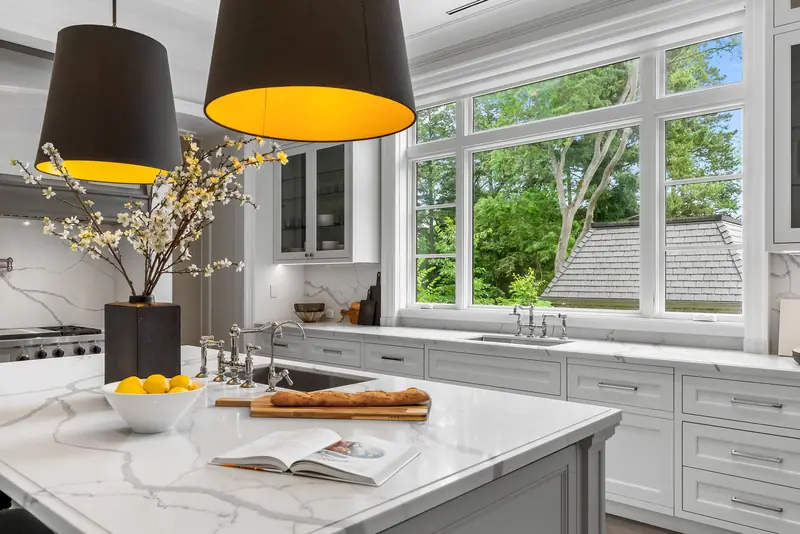 Marble kitchen island under oversized black pendants