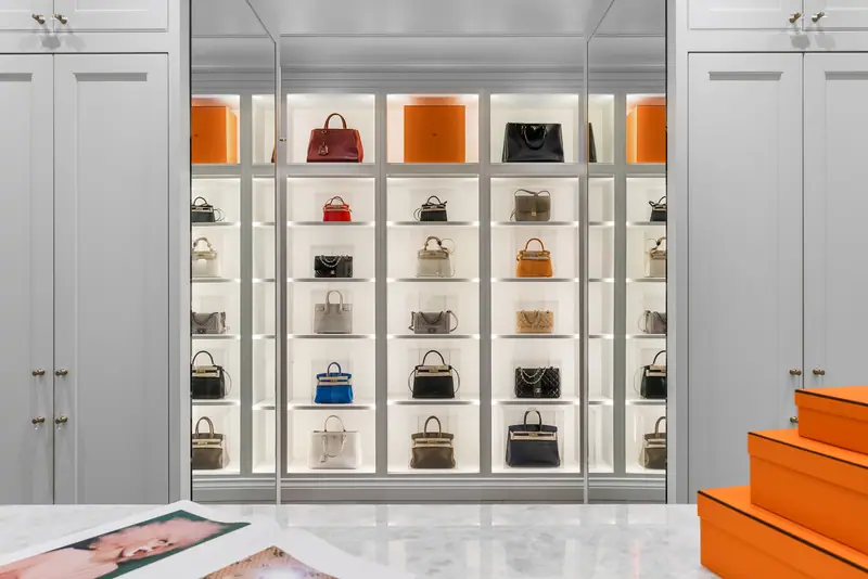 Dressing room with lit handbag display wall