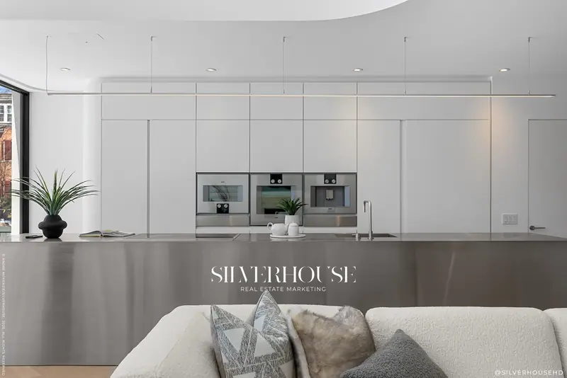 Stainless kitchen island with integrated wall of ovens