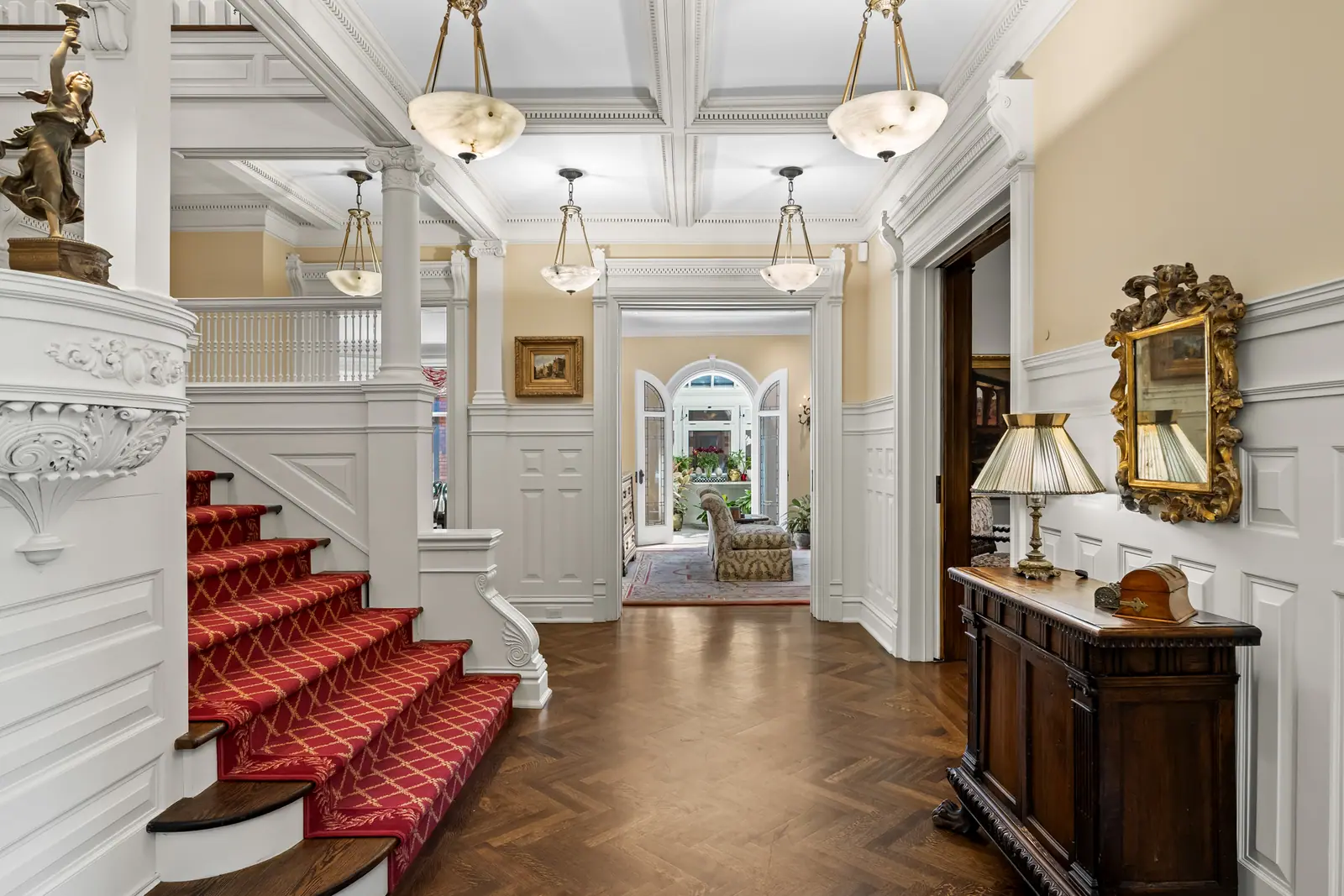 Grand foyer with carved staircase and red runner