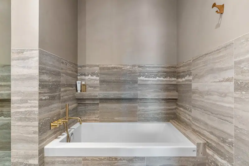 Travertine bathroom with gold fixtures