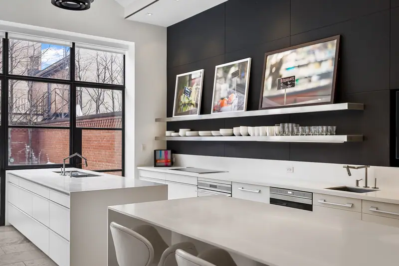 White kitchen with a gallery shelf of framed photographs