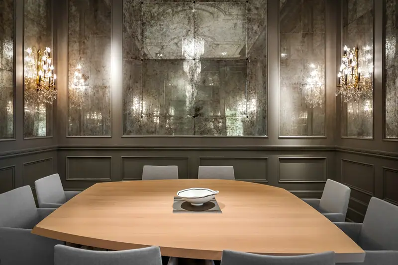 Dining room wrapped in antique mirror with crystal sconces
