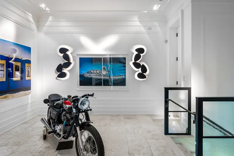 Gallery landing with a vintage motorcycle under sculptural lighting