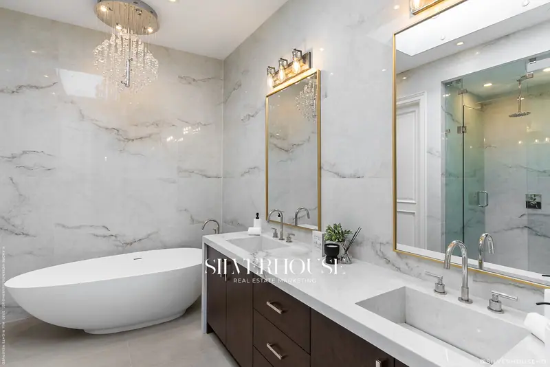 Ensuite with freestanding tub and brass mirrors