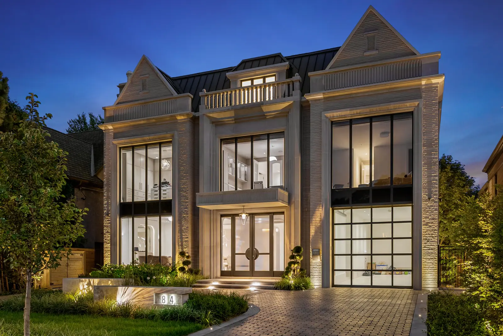 Limestone facade and landscaped front garden at dusk