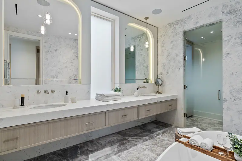 Primary ensuite with arched backlit mirrors and floating double vanity