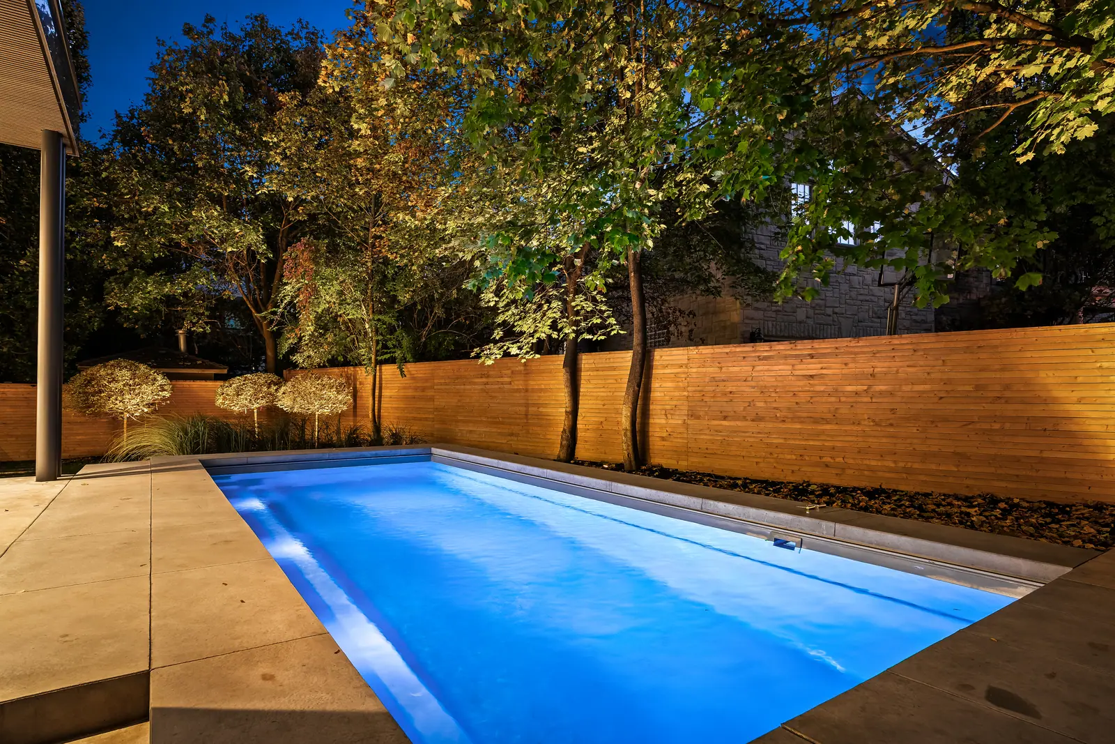 Lit pool and covered terrace at dusk